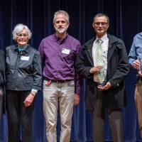 faculty smiling on stage